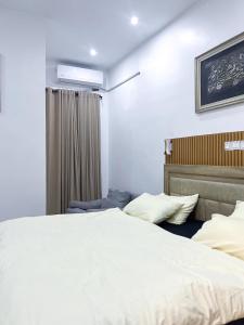 a bedroom with a large white bed and a window at Oak Atlantic Layout - OTITO Suites in Lekki