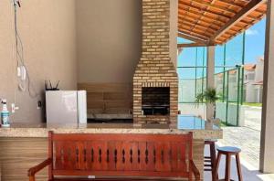 a wooden bench in a kitchen with a fireplace at Reserva Aconchegante perto Praias, Aeroporto, UFDPar, UESPi in Parnaíba