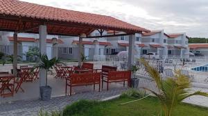 a patio with red chairs and tables in a resort at Reserva Aconchegante perto Praias, Aeroporto, UFDPar, UESPi in Parnaíba