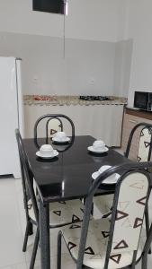 a black table with four chairs and a kitchen at Suíte Lençóis - Quarto amplo com Cozinha Integrada in Lençóis +22 photos