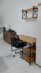an office with a wooden desk and a chair at Suíte Lençóis - Quarto amplo com Cozinha Integrada in Lençóis