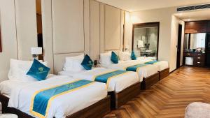 a hotel room with three beds with blue pillows at Diamond Hotel Bỉm Sơn Thanh Hóa in Bỉm Sơn +9 photos
