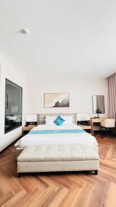 a bedroom with a large white bed and wooden floors at Diamond Hotel Bỉm Sơn Thanh Hóa in Bỉm Sơn