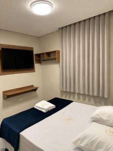 a bedroom with two beds and a flat screen tv at Hotel New City in Guarulhos +42 photos