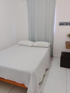 a bed with white sheets and pillows in a room at Reserva Aconchegante perto Praias, Aeroporto, UFDPar, UESPi in Parnaíba +42 photos