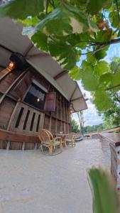a wooden building with two chairs and an umbrella at Mocha Latte Homestay & Cafe in Chiang Rai