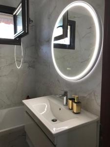 a bathroom with a white sink and a mirror at Aeria Elegant Luxury Villa in Asprovalta