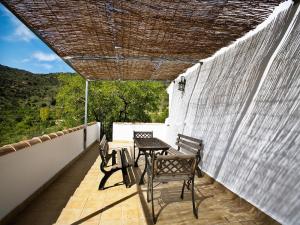 a patio with a table and chairs on a balcony at 4-Guest Laroya Cottage with Pool in Laroya
