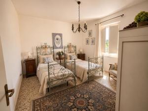 a bedroom with two beds and a chandelier at La Casetta in San Terenziano +13 photos