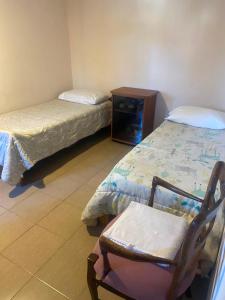 a room with two beds and a chair in it at Depto Candioti excelente ubicación Aire Calefacción Wifi in Santa Fe +1 photo