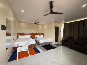 a bedroom with two beds and a couch at S R RESORTS in Chīrāla