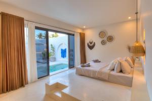 a bedroom with a bed and a large window at Villa Calipso in Gili Trawangan