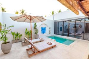 a villa with a swimming pool and an umbrella at Villa Calipso in Gili Trawangan