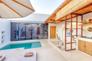 a house with a swimming pool in the middle of it at Villa Calipso in Gili Trawangan
