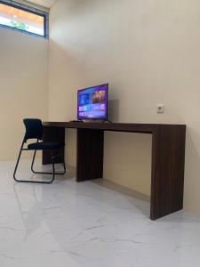 a desk with a computer sitting on top of it at Semar Hotel in Tjakranegara