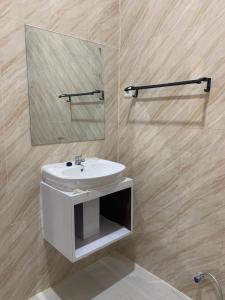 a bathroom with a white sink and a mirror at Semar Hotel in Tjakranegara