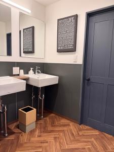 a bathroom with two sinks and a blue door at 出雲大社まで徒歩5分 一棟貸し宿 はれいろ in Izumo