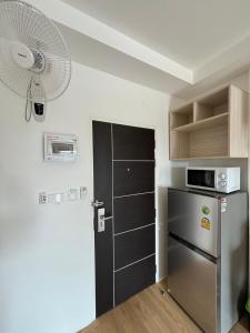 a kitchen with a refrigerator and a fan at เจฮอนโด อพาร์ตเมนต์ in Ban Si Than