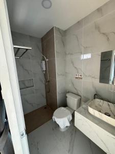 a bathroom with a toilet and a sink and a shower at เจฮอนโด อพาร์ตเมนต์ in Ban Si Than +14 photos