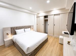 a bedroom with a large bed and a flat screen tv at เจฮอนโด อพาร์ตเมนต์ in Ban Si Than