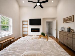 a bedroom with a large bed with a ceiling fan at Casa Blanca Luxury Spa Suite with fireplace, Disc Golf, 5 beds in Tulsa