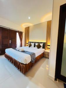 a bedroom with a large bed in a room at Jesens Inn II in Kuta +74 photos