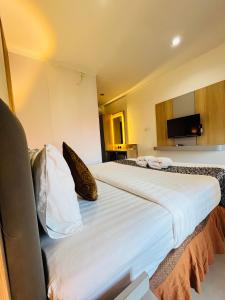 a hotel room with two beds and a tv at Jesens Inn II in Kuta