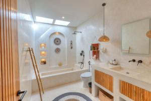 a bathroom with a tub and a toilet and a sink at Villa Afrodite in Gili Trawangan