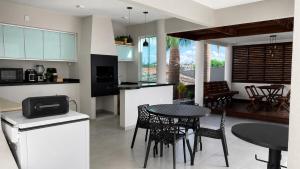 a kitchen and dining room with a table and chairs at Recanto Veraneio in Londrina
