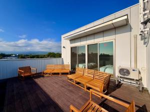 a deck with three wooden benches on a building at Grand Opening SORA Yunokawa Penthouse in Hakodate