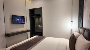 a bedroom with a bed and a tv on a wall at LION 7 HOTEL in Can Tho