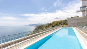 a swimming pool on top of a building with a view of the ocean at TOTO Seawind Awaji in Awaji