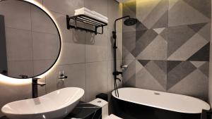 a bathroom with a tub and a sink and a mirror at LION 7 HOTEL in Can Tho