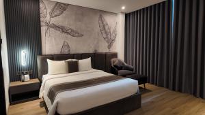 a bedroom with a large bed and a chair at LION 7 HOTEL in Can Tho