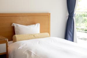 a bedroom with a white bed and a window at TOTO Seawind Awaji in Awaji +31 photos
