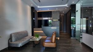 a lobby with a couch and a chair and a table at LION 7 HOTEL in Can Tho
