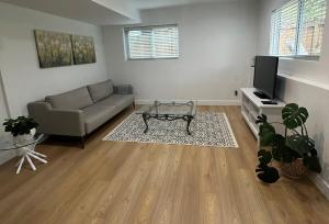 a living room with a couch and a tv at Bright & Cozy Garden Level Suite in North Vancouver