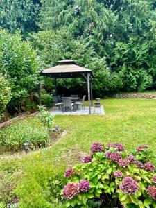 a garden with a gazebo and tables and flowers at Bright & Cozy Garden Level Suite in North Vancouver