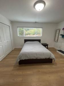 a bedroom with a large bed and a window at Bright & Cozy Garden Level Suite in North Vancouver