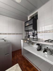 a white kitchen with a sink and a stove at Bahamas House in Ibagué +16 photos