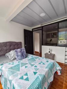 a bedroom with a bed with a quilt on it at Bahamas House in Ibagué