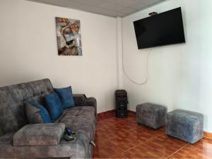 a living room with a couch and a flat screen tv at Bahamas House in Ibagué