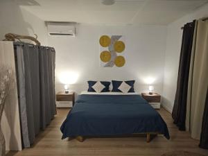 a bedroom with a bed with blue sheets and two lamps at Paradies Caraïbes II in Les Abymes