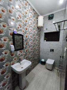 a bathroom with a sink and a flower patterned wall at Comfy Stay in Dehradun