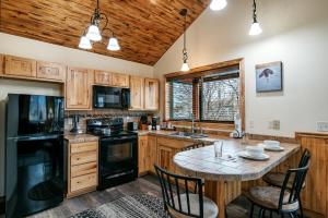 a kitchen with wooden cabinets and a table with chairs at Yellowstone Riverside Cottages in Gardiner