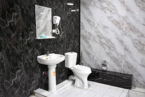 a black and white bathroom with a toilet and a sink at Amor fati hotel Tashkent in Katartal +57 photos