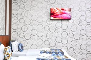 a bedroom with a tv hanging on a wall at Amor fati hotel Tashkent in Katartal