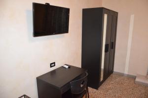 una stanza con un armadio nero e una televisione sul muro di Bed&Breakfast Villa Bellini a Catania