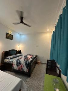 a bedroom with a bed and a ceiling fan at The quiet corner homestay in Rudraprayāg +3 photos