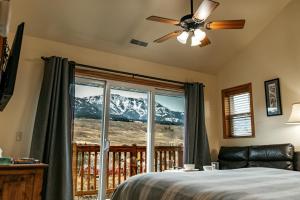 a bedroom with a bed and a window with a mountain view at Yellowstone Riverside Cottages in Gardiner